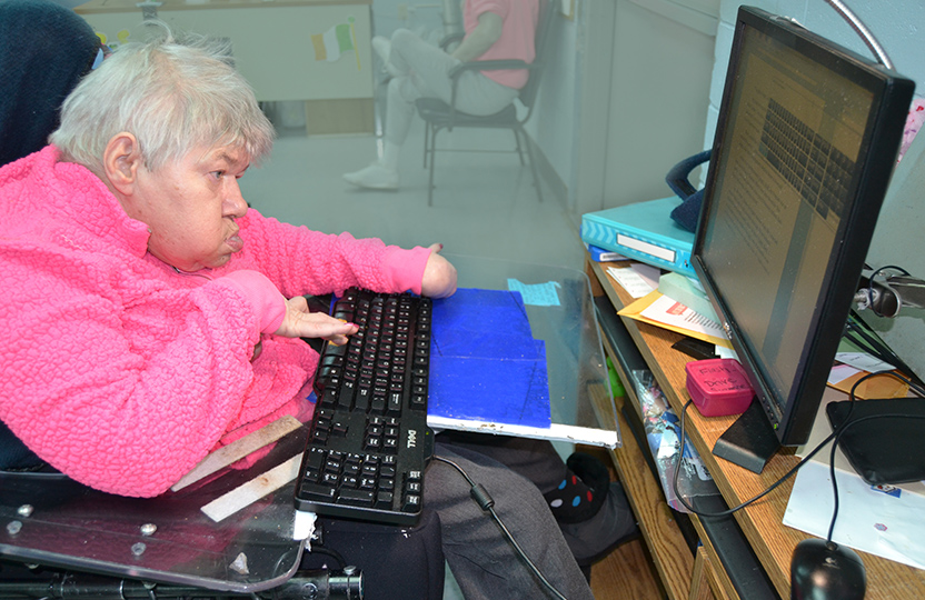 Women in wheel chair typing on computer