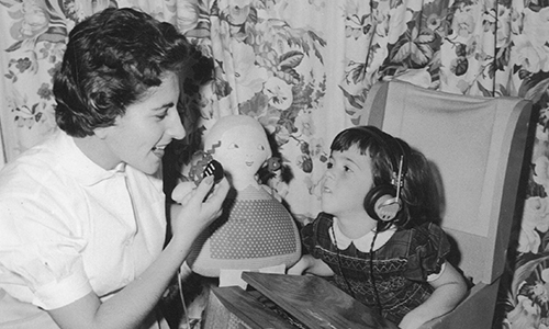 Historical photo of a nurse with student using assistive technology